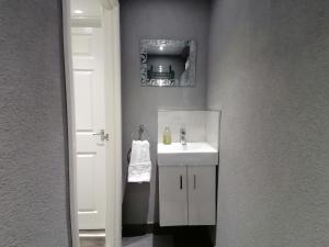 考文垂Charming 1-Bed Apartment in Coventry的一间带白色水槽和白色门的浴室