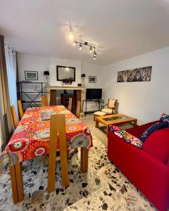 阿尔克昂巴鲁瓦Le gîte de l’espérance的客厅配有桌子和红色沙发