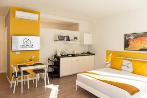 里米尼Corso51 Suite Apartments的一间卧室配有一张床和一个小厨房