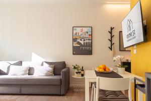 里米尼Corso51 Suite Apartments的客厅配有沙发和桌子