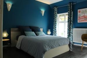 Wargnies-le-GrandGîte La Riviera的蓝色的卧室设有床和窗户