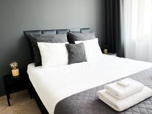 格丁尼亚Pokoje Gościnne Przy Molo的卧室配有一张白色大床和两条毛巾