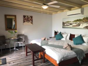 DivunduWhite Sands Lodge的一间设有两张床和一张桌子的房间