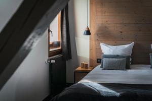 圣沙夫雷Grand Hôtel & Spa NUXE Serre Chevalier的一间卧室配有一张带木制床头板的床