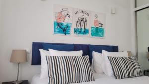 ArcozeloAguda Golf Vita的一张带四个枕头的床和墙上的两张照片