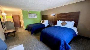 特里沃斯林肯费城酒店的酒店客房,配有两张带蓝色床单的床