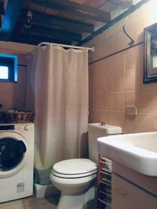 卡尔达纳I Poderi - Lovely Country House in Maremma的浴室配有卫生间、盥洗盆和洗衣机。