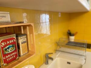 阿尔勒La maison de Fanny的厨房设有水槽和黄色的墙壁
