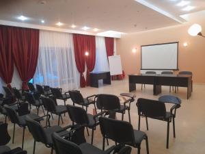 波亚纳布拉索夫Hotel Miraj - Restaurant & Sauna & Biliard的一间设有钢琴、椅子和屏幕的房间
