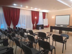 波亚纳布拉索夫Hotel Miraj - Restaurant & Sauna & Biliard的一间带椅子、钢琴和屏幕的房间