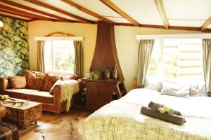 格罗宁根Bamboo Lodge Groningen的一间卧室配有一张床、一张沙发和一把椅子