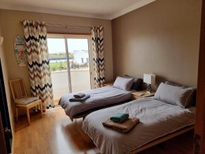 吉亚Jardim Paraiso Guia的一间卧室设有两张床和一个美景窗户。