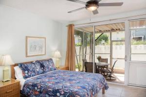乔治敦Beach Living at Island Pine Villas (BLJ)的一间卧室配有一张床、一张桌子和一个窗户。