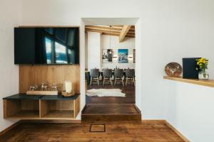 瑟弗浩斯Serfaus Alpensuites的一间设有桌子的用餐室和墙上的电视