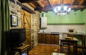 塔拉蒙迪Casas Rurales Taramundi Verde的一间厨房,内设一张桌子和吊灯