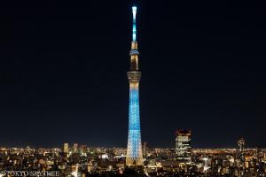 东京Henn na Hotel Tokyo Asakusa Tawaramachi的夜晚高高的塔楼里点着蓝色的灯光