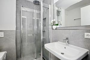 奥斯赛拜-屈隆斯博恩Strandresidenz Dünenperle Wohnung 9的带淋浴和白色盥洗盆的浴室