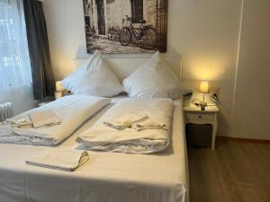 蒙绍Eifelerhof hotel Monschau的一张带白色床单和毛巾的床