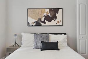 芝加哥1BR Calm & Cozy Apt in Lincoln Square - Eastwood 2S的卧室配有一张白色的床,上面有一张图画