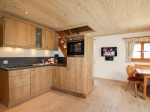 因泽尔Weissenhof - Chiemgau Karte的厨房配有木制橱柜、桌子和窗户。