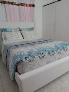 卡塔赫纳Casa ITCI Tours的床上有蓝色和白色的毯子