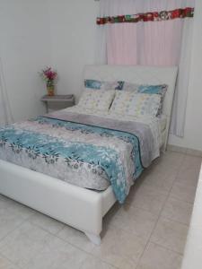卡塔赫纳Casa ITCI Tours的白色的床和蓝色和白色的毯子