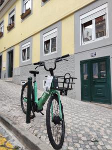 里斯本Apartamento acolhedor no coração de Lisboa的停在大楼前的绿色自行车
