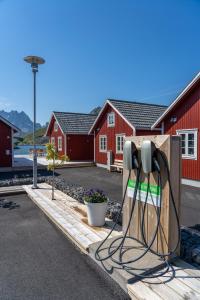 拉姆贝格Lofoten Cabins - Kåkern的红色建筑前的一部手机充电器