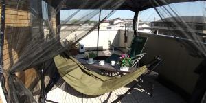 雾岛市Guest House Mulberry - Vacation STAY 9580的阳台配有吊床和桌椅。