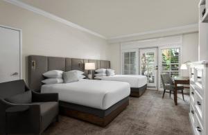 圣地亚哥勒奥伯奇德尔马水疗度假酒店的一间卧室配有两张床、一张桌子和一把椅子
