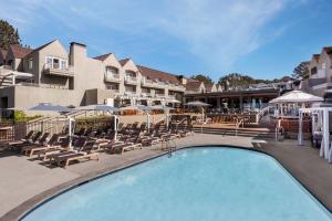 圣地亚哥勒奥伯奇德尔马水疗度假酒店的游泳池,带椅子和遮阳伞