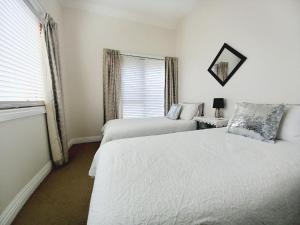 沃纳姆堡Ocean Aspect and Central to CBD - CoSheirm Apartments On Merri的一间卧室设有两张床和窗户。