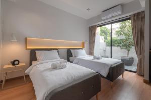 清迈Eleven Pillar Site Chiangmai的一间卧室设有两张床和大窗户