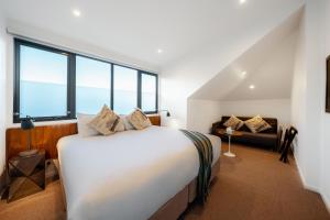 悉尼克雷蒙角曼诺尔酒店的卧室配有一张白色的大床和一张沙发。