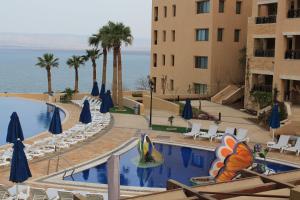 索瓦马Samarah Dead Sea Resort Studio-CP6 Traveler Award 2023 Winner的一座酒店,在一座建筑旁边设有游泳池