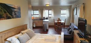 赫罗德斯湾Agape holiday house的一间带床和厨房的客厅