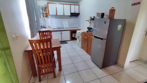 MahinaManava Tahara'a Home Stay的厨房配有冰箱和桌椅