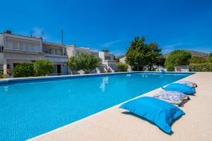 阿尔库迪亚Ideal Property Mallorca - Avus的一座带蓝色枕头的游泳池,位于大楼旁边