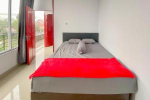 TomohonSky Residence Tomohon Mitra RedDoorz的一张床上的床上,上面有红毯