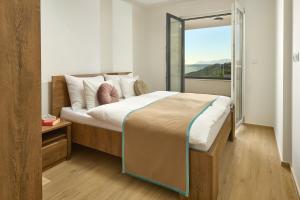 马卡尔斯卡Sun Spalato Residence的一间卧室设有一张大床和大窗户