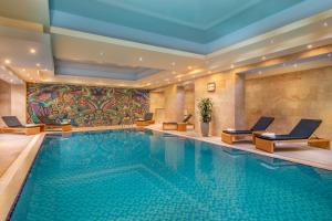 埃里温国家大酒店的一座带椅子和画作的酒店游泳池
