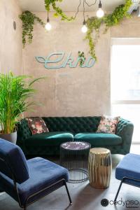 圣埃格雷夫Ekho Hotel Grenoble Nord Saint Egrève的客厅配有绿色沙发和椅子