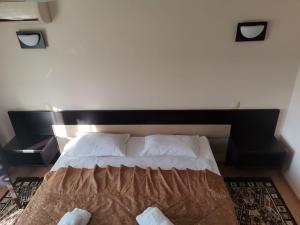 雅西Pensiunea Eric的一间卧室配有一张带木制床头板的床