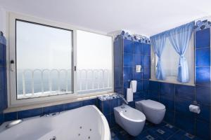 阿马尔菲拉宁法酒店的蓝色瓷砖浴室设有浴缸和卫生间