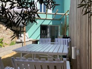 瓦讷DU MANN petite maison jardin à 100m du port de Vannes avec PARKING的野餐桌和两把白色椅子位于房子前面