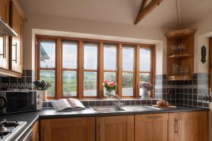 阿贝尔格莱Beautiful Countryside cottage on the North Wales Coast的厨房设有水槽和窗户。