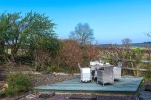 阿贝尔格莱Beautiful Countryside cottage on the North Wales Coast的木甲板上的桌椅