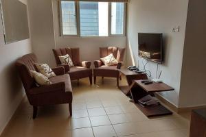 科伦坡Jays Apartment - Colombo 02 at the heart of convenience的客厅配有椅子和平面电视