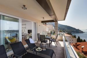 杜布罗夫尼克Amorino Of Dubrovnik Apartments的阳台配有桌椅,享有水景。