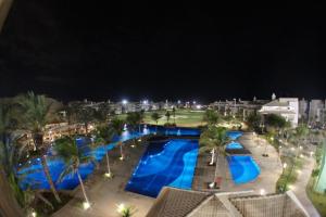 阿奎拉兹Golf Ville Resort in Beach Park的夜间享有度假村游泳池的顶部景致